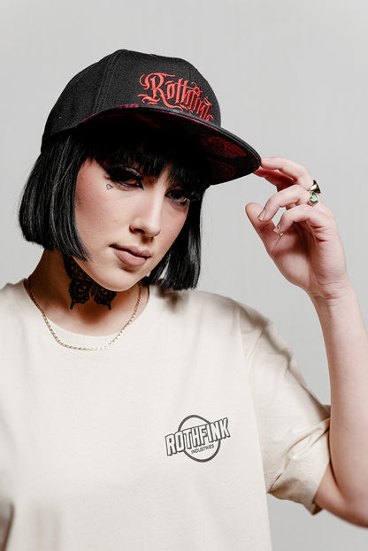 Person wearing a black cap with 'Rothfink' logo and a matching t-shirt on a plain background